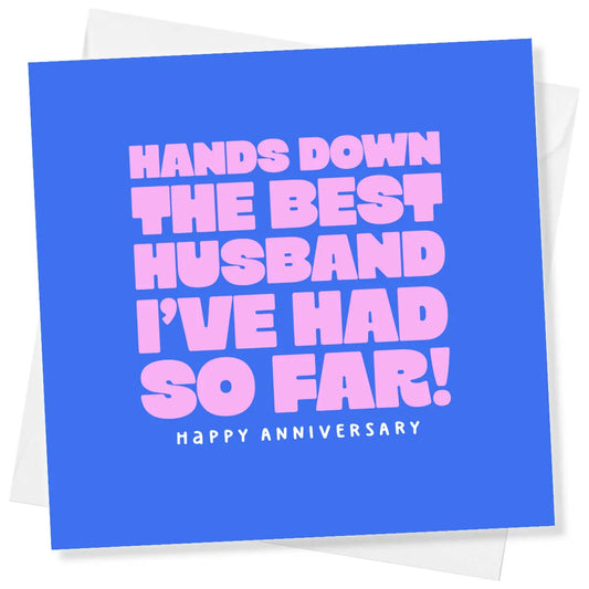 Funny anniversary card with bold pink text on blue saying 'Hands down the best husband I’ve had so far! Happy anniversary'.
