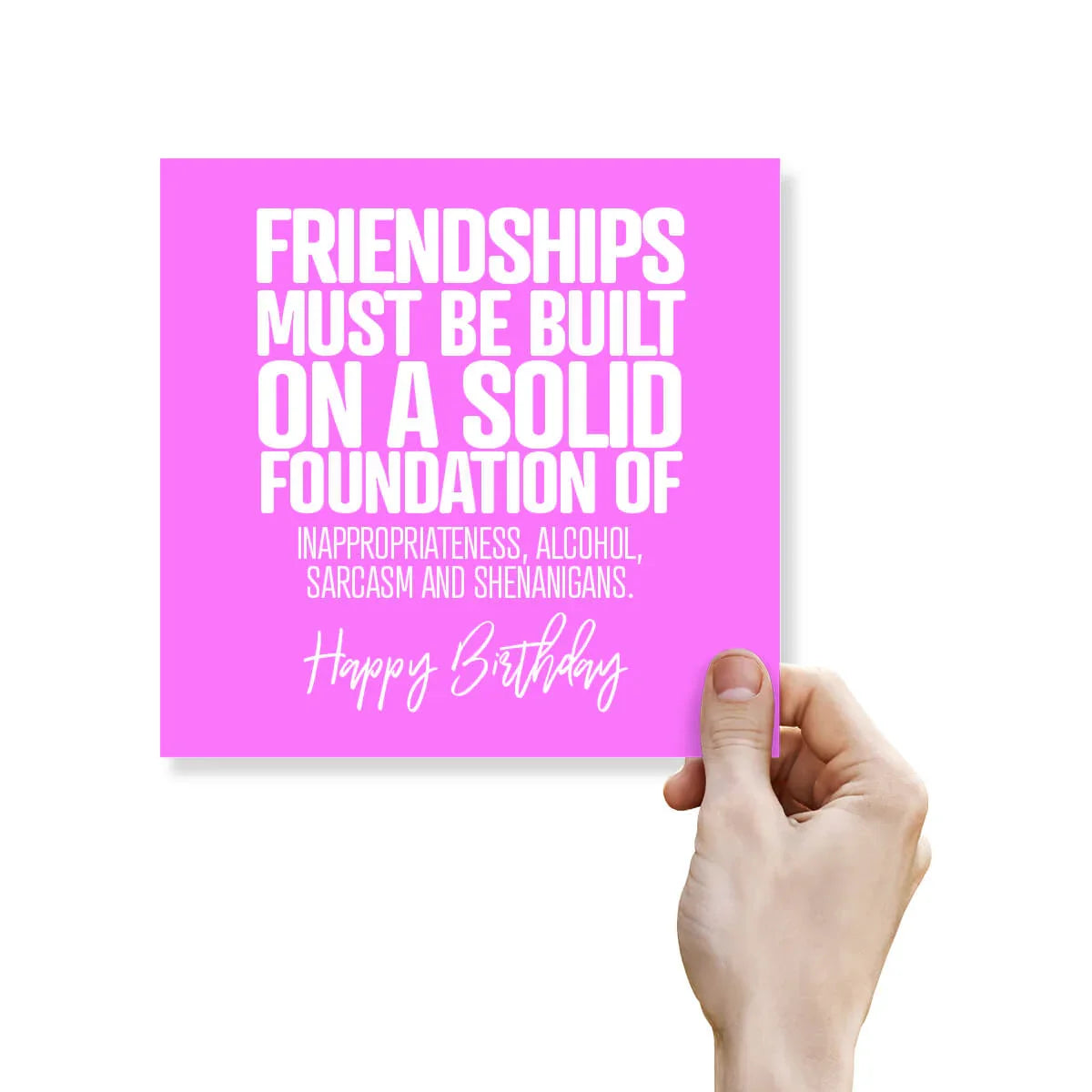Hand holding a pink card with humorous birthday message on a white background