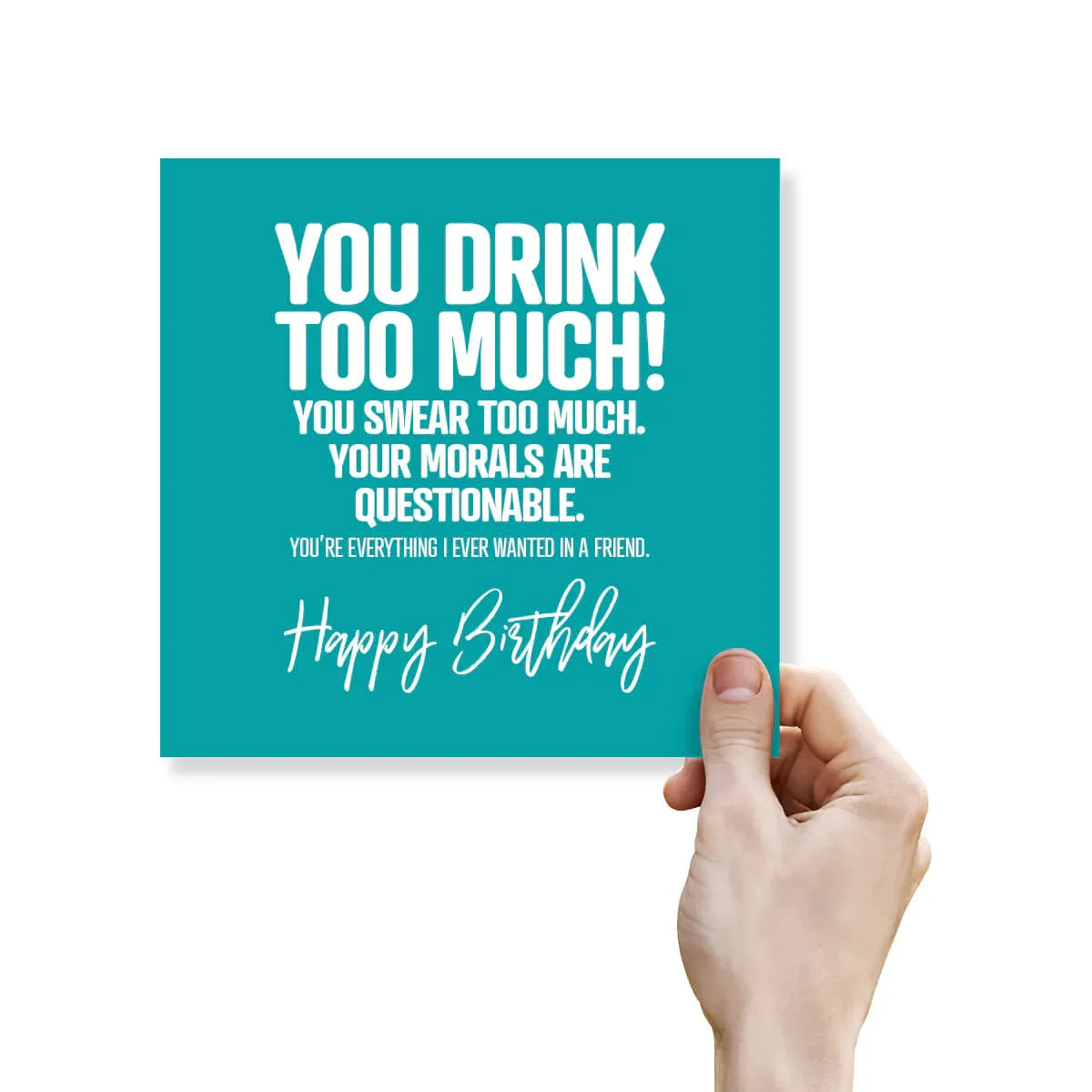 Hand holding a teal birthday card with humorous text on a white background