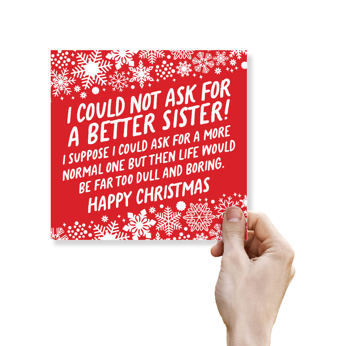 A hand holding a square red Christmas greeting card with white snowflake borders and white text that reads, 'I COULD NOT ASK FOR A BETTER SISTER! I SUPPOSE I COULD ASK FOR A MORE NORMAL ONE BUT THEN LIFE WOULD BE FAR TOO DULL AND BORING. HAPPY CHRISTMAS.