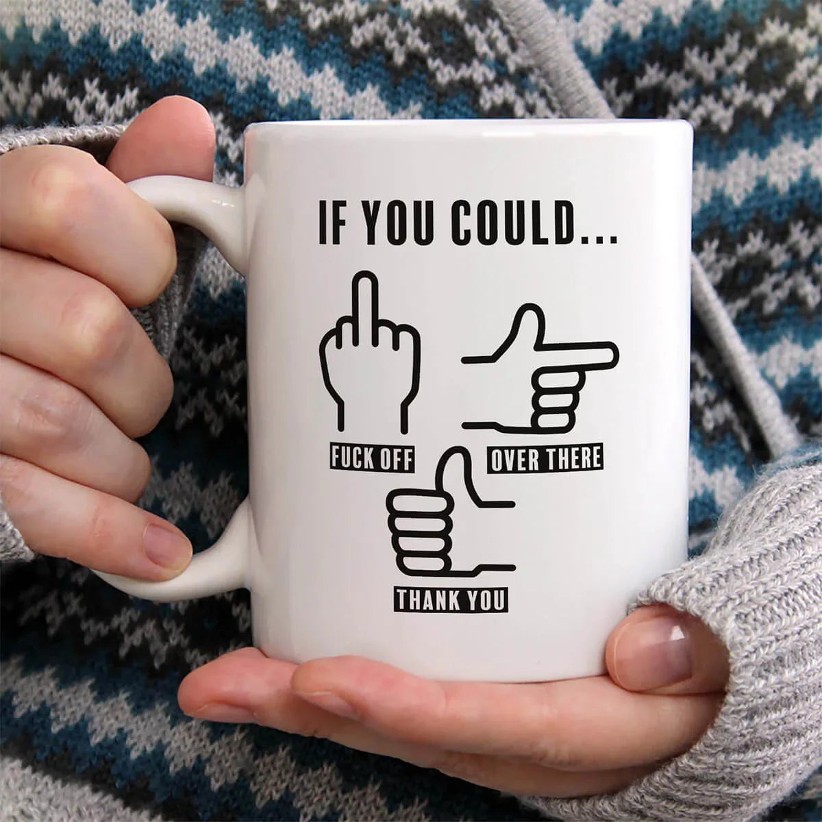 Person holding a mug with a graphic design and text.