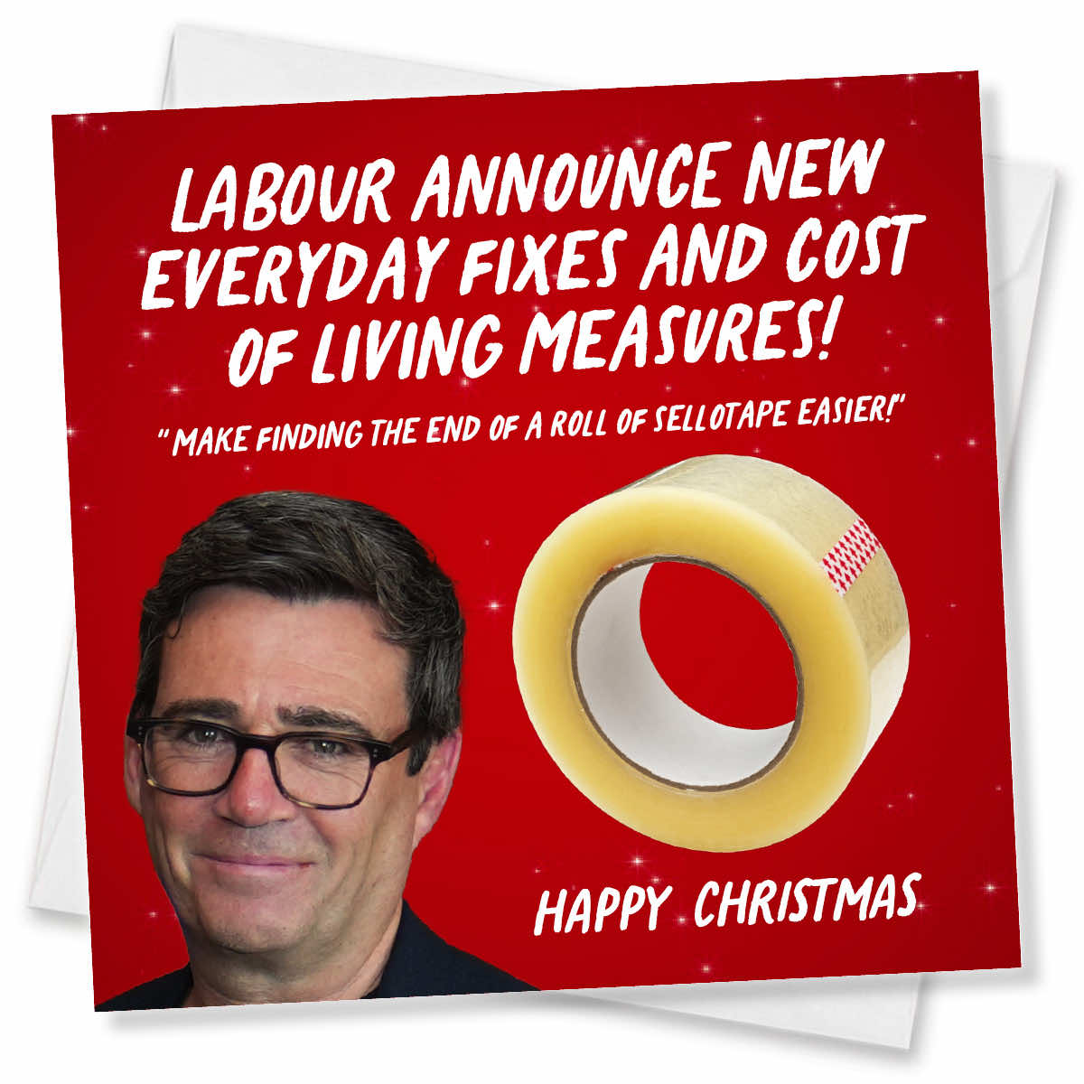 A square Christmas greeting card with a red background, white text, a photo of Jeremy Corbyn, and a roll of clear tape graphic. The card reads: 'LABOUR ANNOUNCE NEW EVERYDAY FIXES AND COST OF LIVING MEASURES! "MAKE FINDING THE END OF A ROLL OF SELLOTAPE EASIER!" HAPPY CHRISTMAS'.