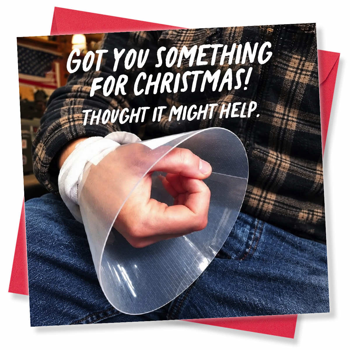 A square printed card or package shown on a red background, featuring a close-up photo of a person wearing a transparent plastic cone restraint over a hand wrapped in white tape. Large white text across the top reads, 'GOT YOU SOMETHING FOR CHRISTMAS! THOUGHT IT MIGHT HELP.