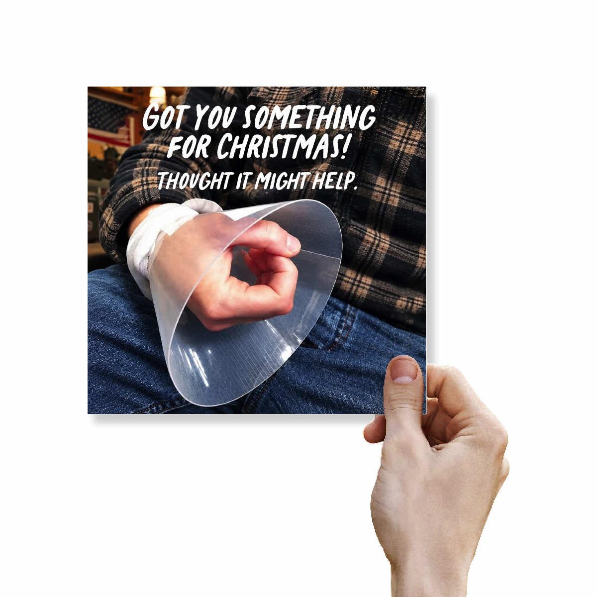 A square printed card or poster is held by a hand against a white background. The card shows a close-up photo of a person wearing a transparent plastic cone collar around a hand that is wrapped in a white bandage, with bold white text reading, 'GOT YOU SOMETHING FOR CHRISTMAS! THOUGHT IT MIGHT HELP.