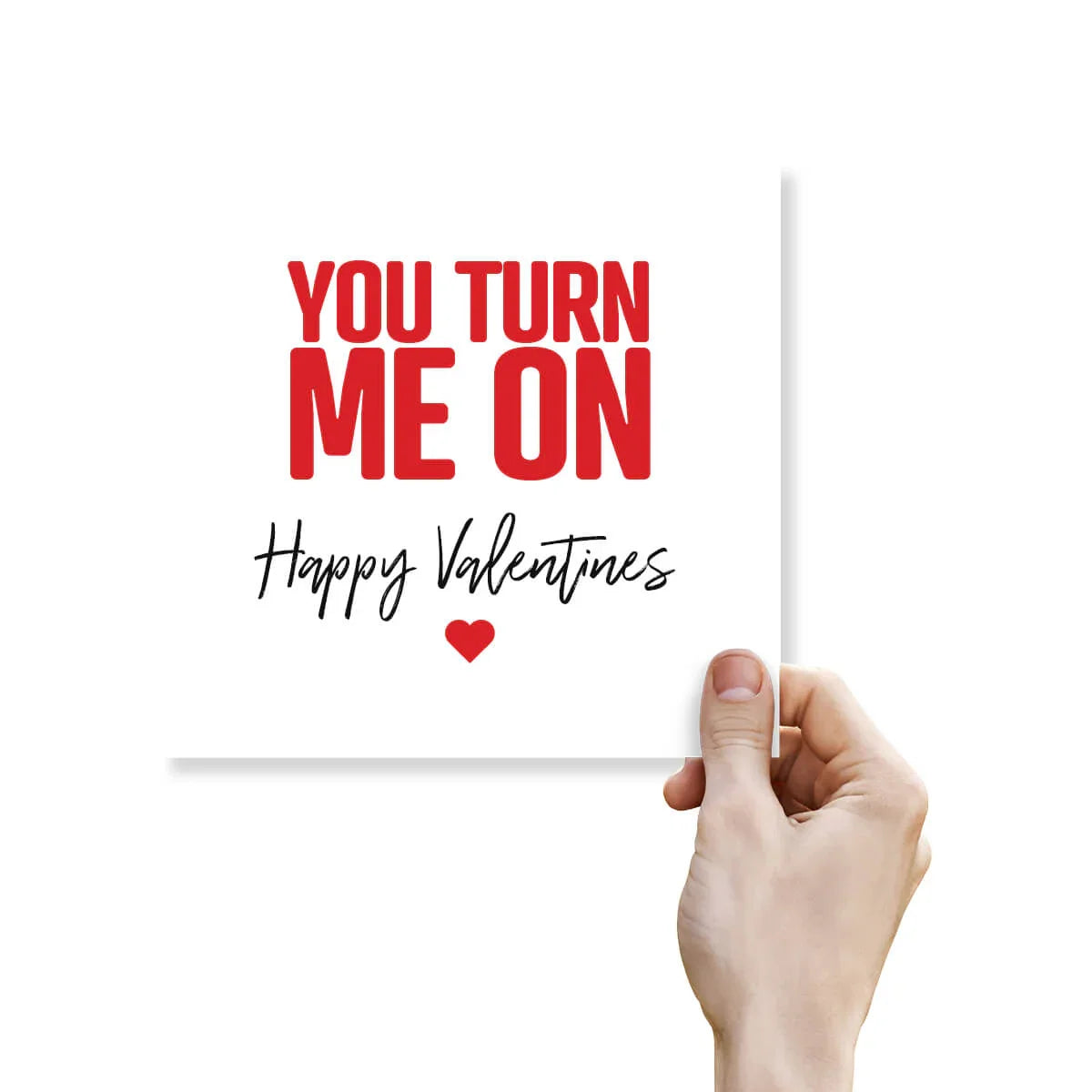 Funny Valentine’s Day card with bold red text saying 'You turn me on' and a hand holding it.