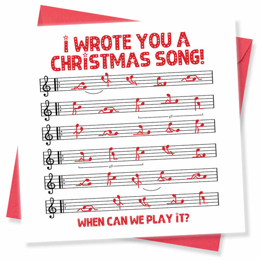 A square white greeting card with red text reading 'I WROTE YOU A CHRISTMAS SONG! WHEN CAN WE PLAY IT?' and black musical staves with red notes, shown with red envelopes behind it on a white background.